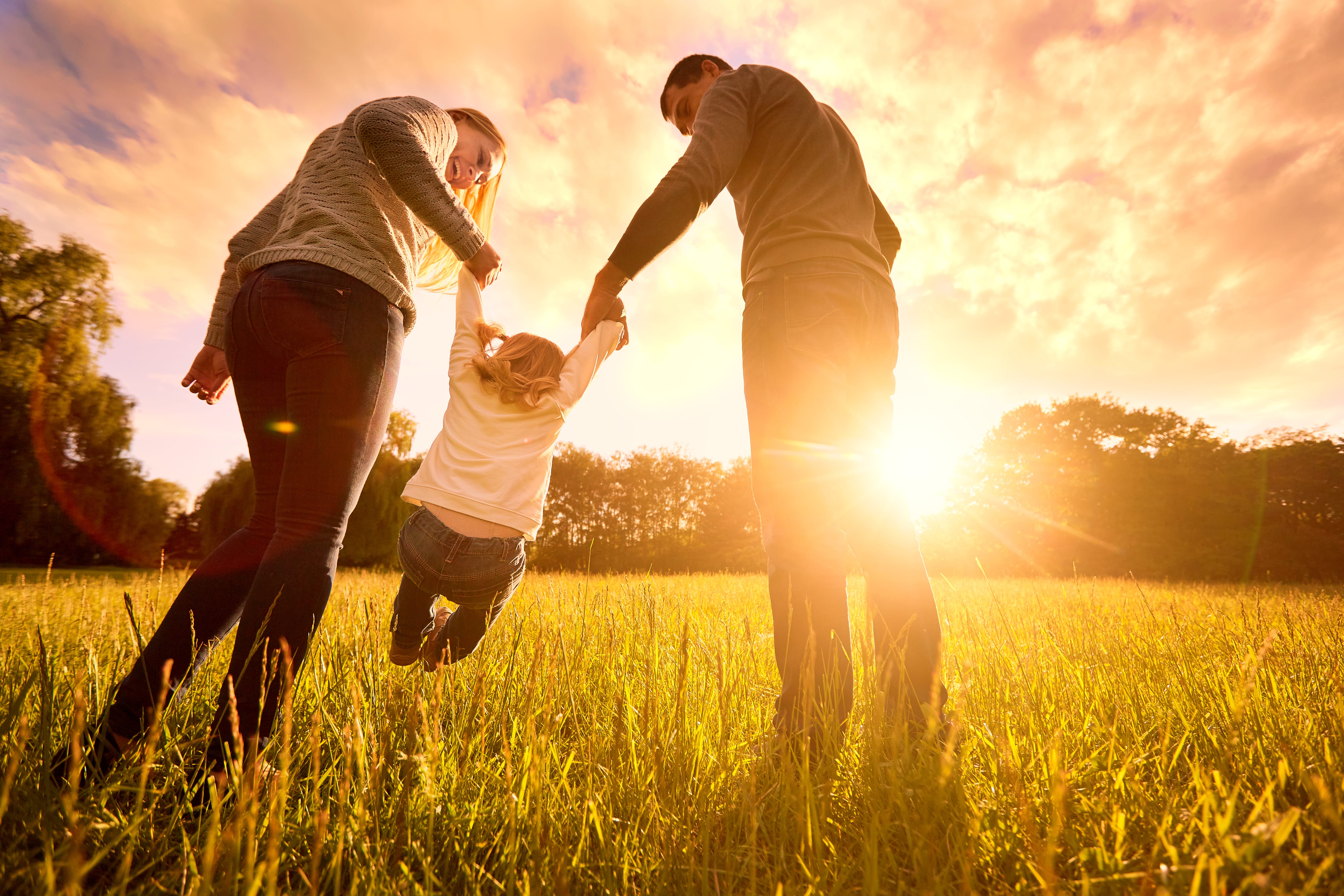 photo of a family playing wiht their child in a field