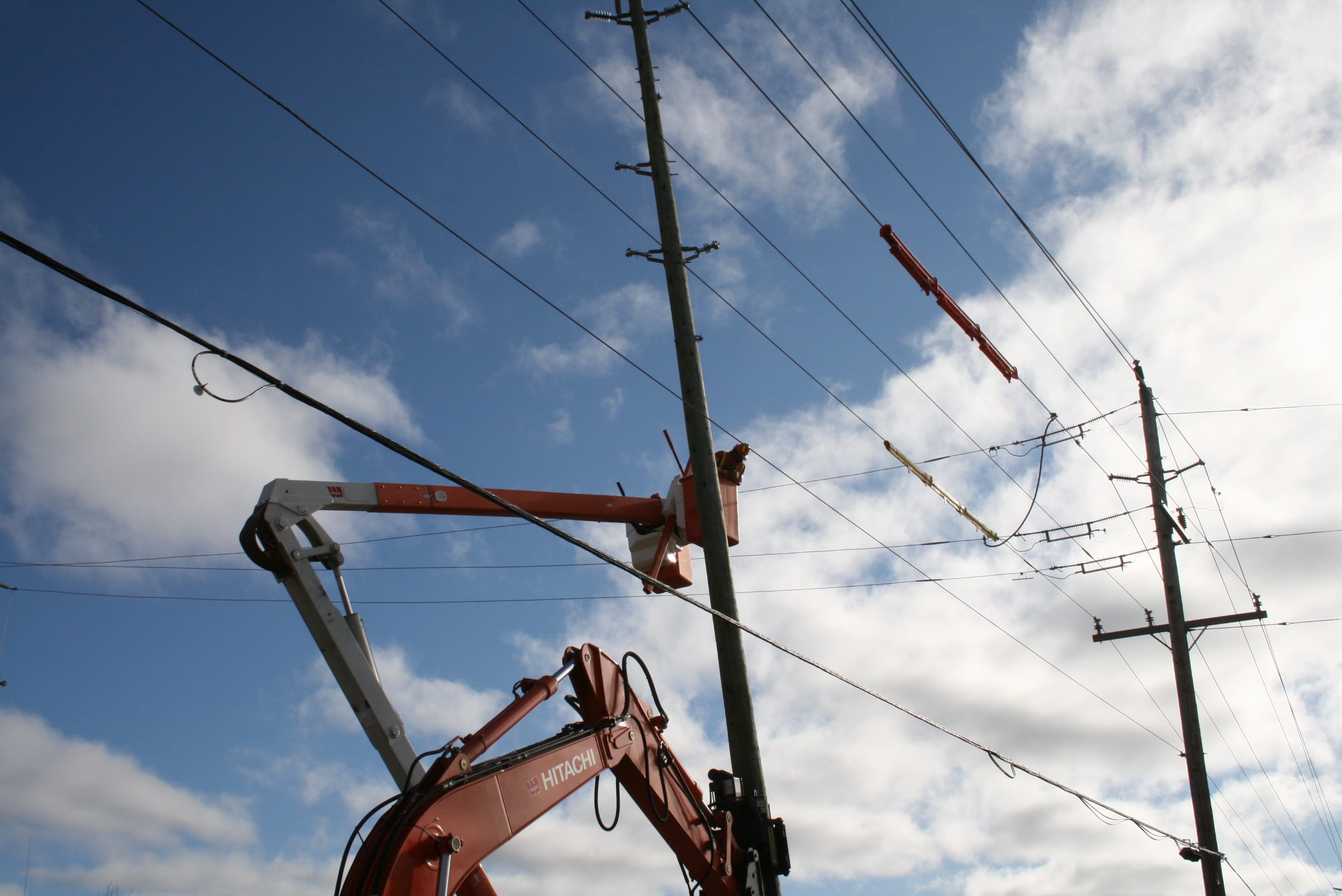 Image of a wood pole being worked on by Hydro One employees 
