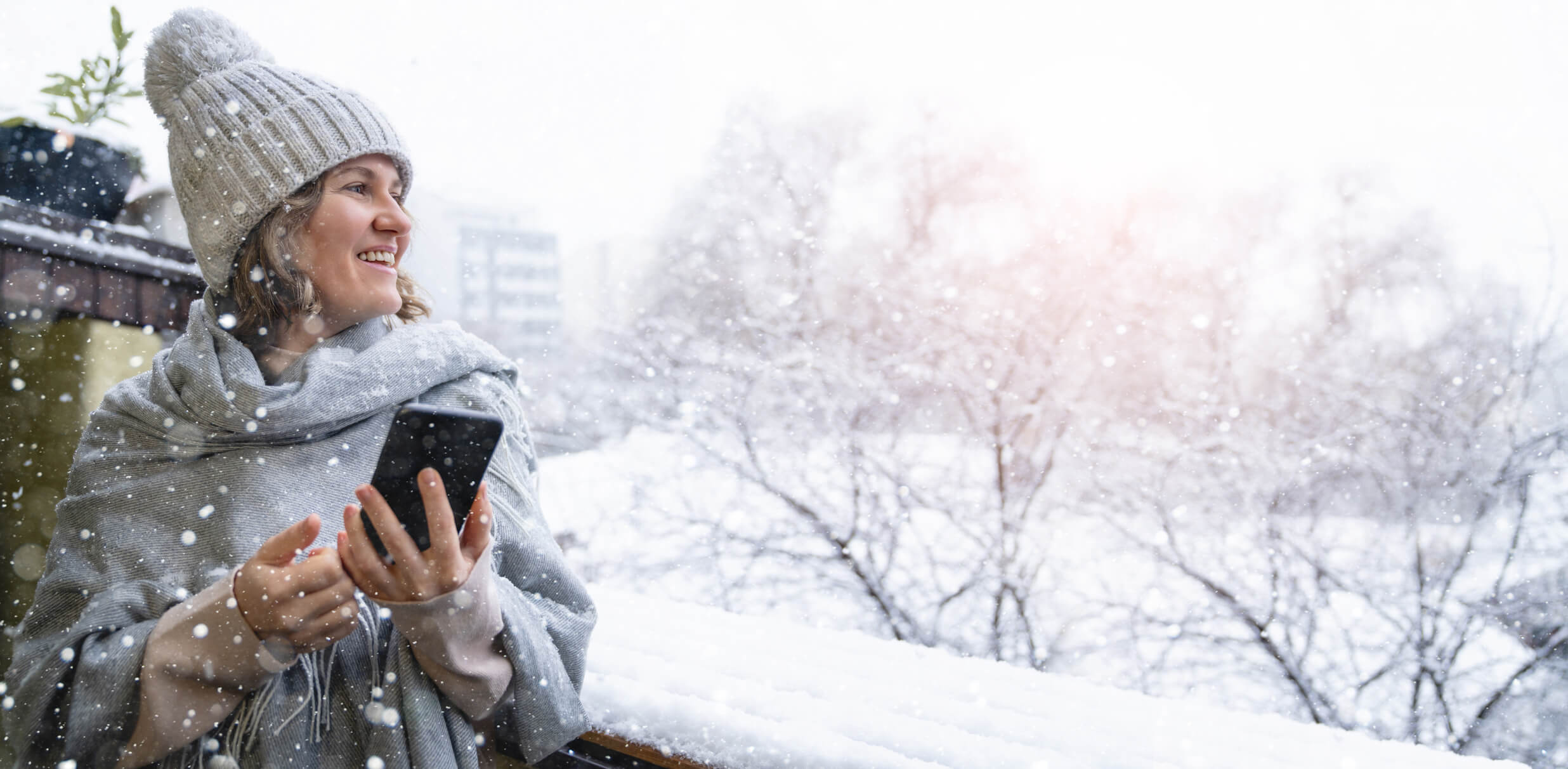 Photo of a woman using a mobile phone outside in winter