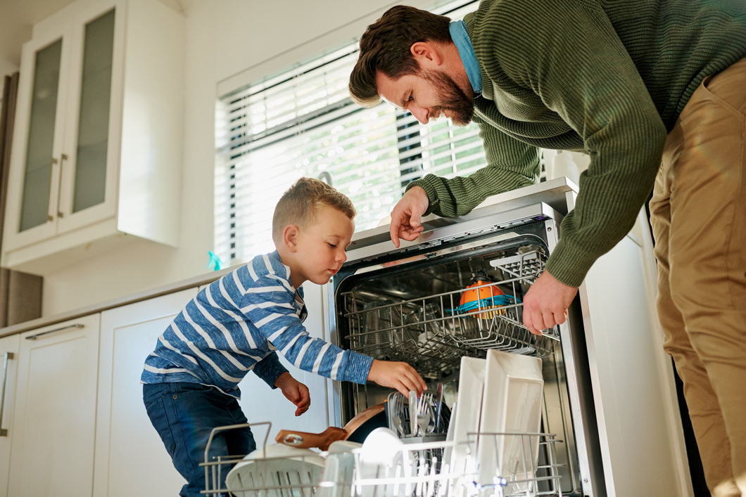 photo of a dad and his young son loading a dishwasher