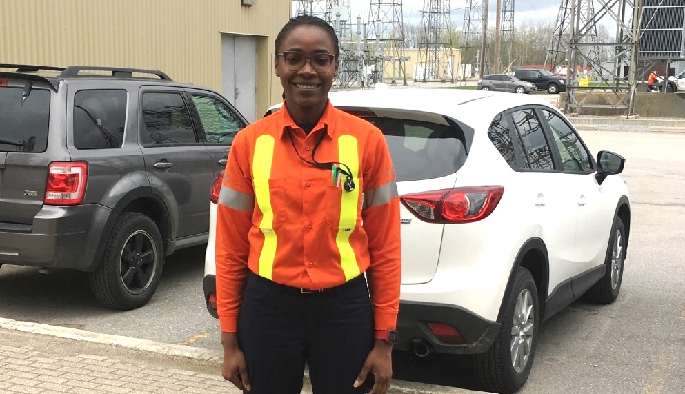 photo of Linda Chigbo standing in front of a Hydro One transformer station
