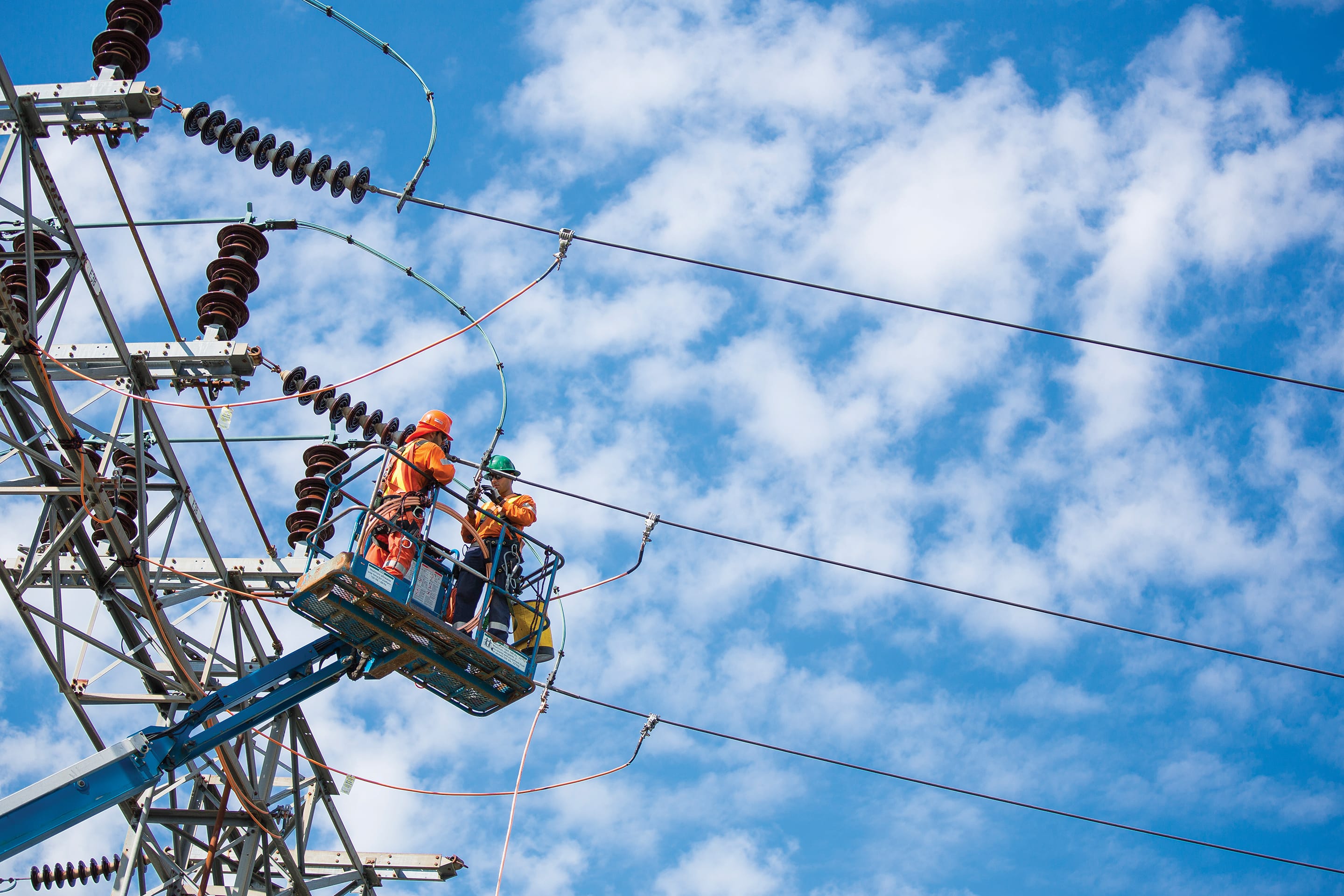 Photo of Hydro One linemen working on a transmission tower
