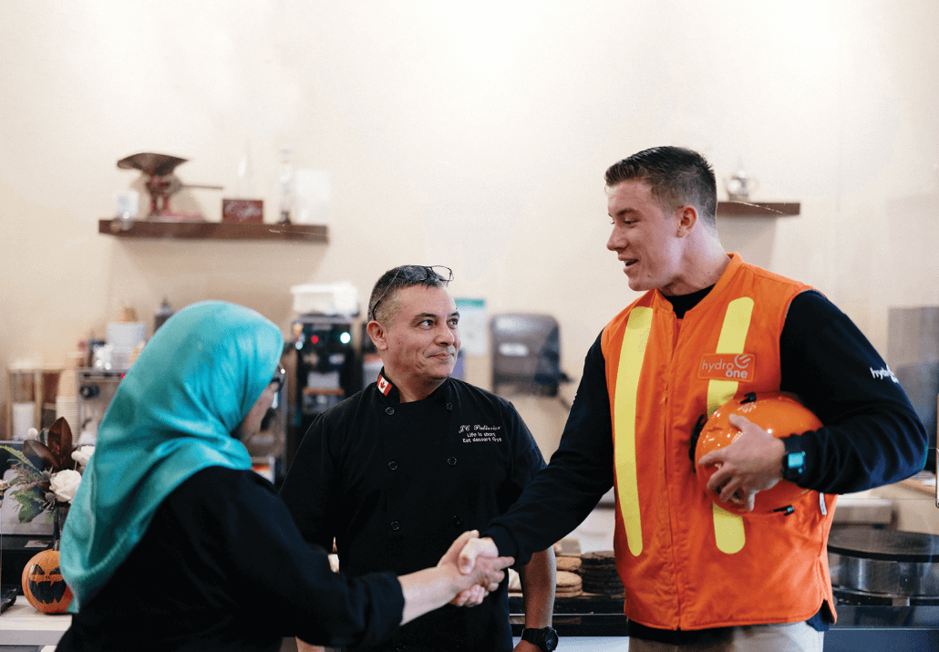 Hydro One employee shaking hands with local business owner