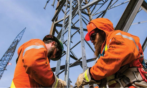 Workers underneath a transmission tower