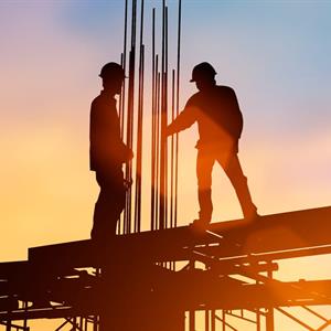 Image of two construction workers on a structure of a home