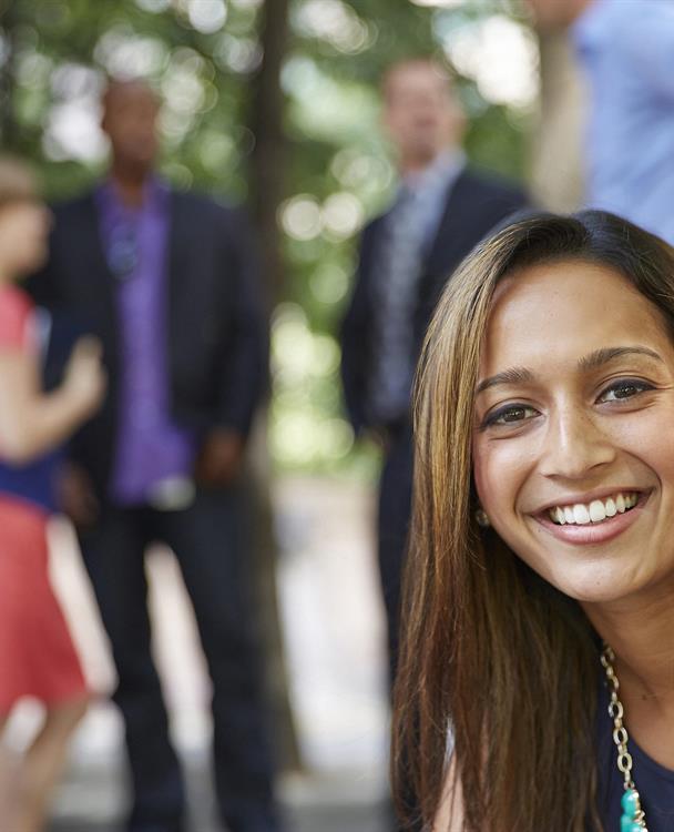 photo of woman in the foreground and businesspeople in the background