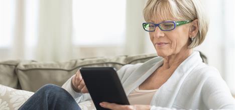Image of a woman sitting down looking at her tablet