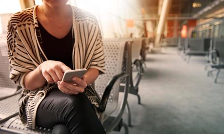 Person using a laptop and phone in an indoor setting
