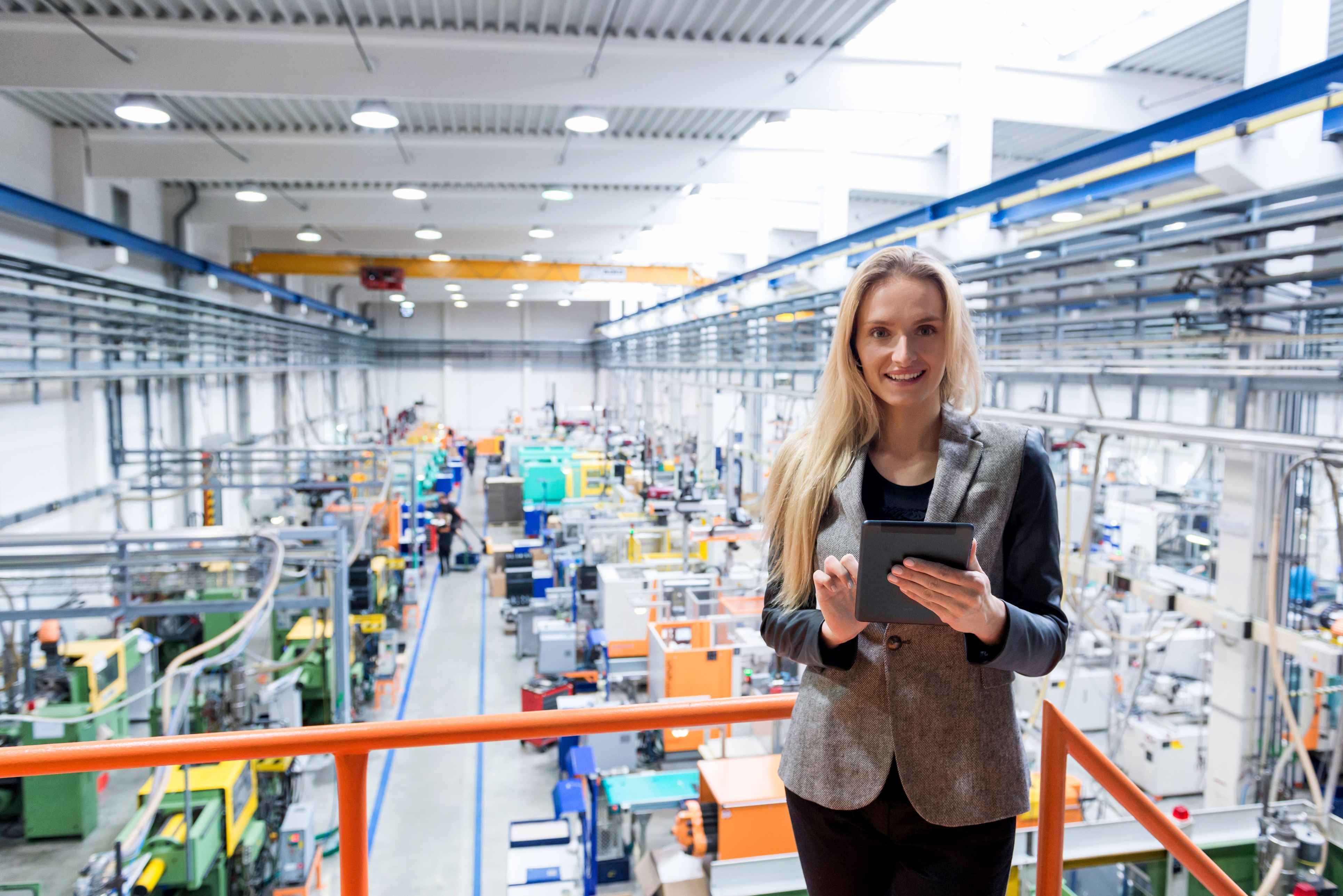 Worker walking through an industrial facility with equipment in the background