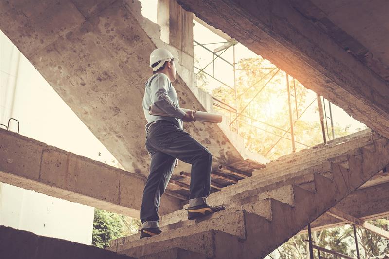 photo of a builder holding blueprints in a partially constructed home