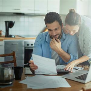 a couple in the kitchen looking over papers