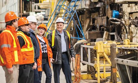 Image of a Hydro One worker with distribution pole in the background