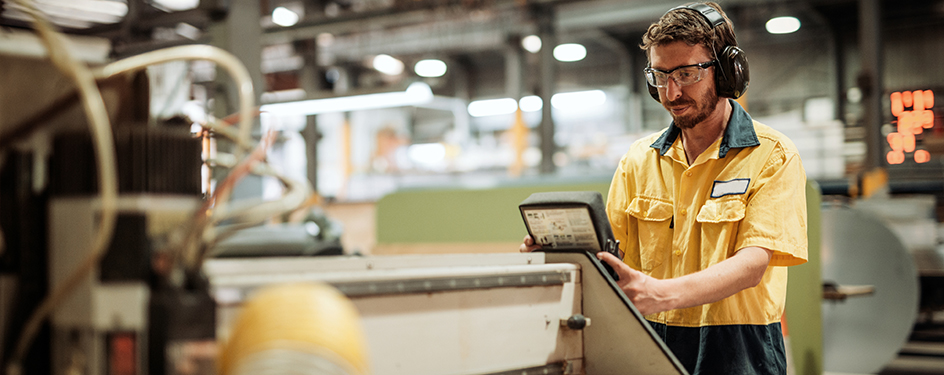 Employee working at a control panel in an industrial facility