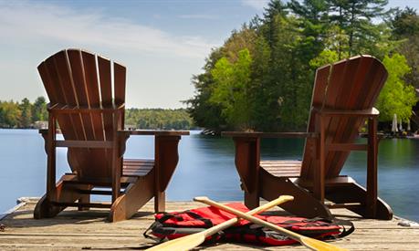 photo of two Muskoka chairs on a dock in Ontario