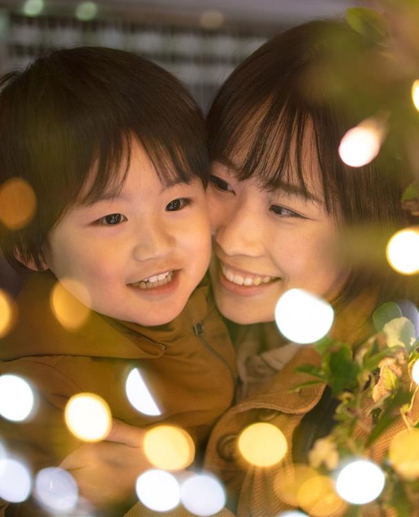 photo of a family near a holiday tree with lighting in the foreground