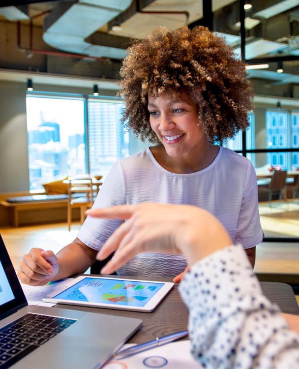 photo of a woman pointing at pie chart graphs on a computer screen