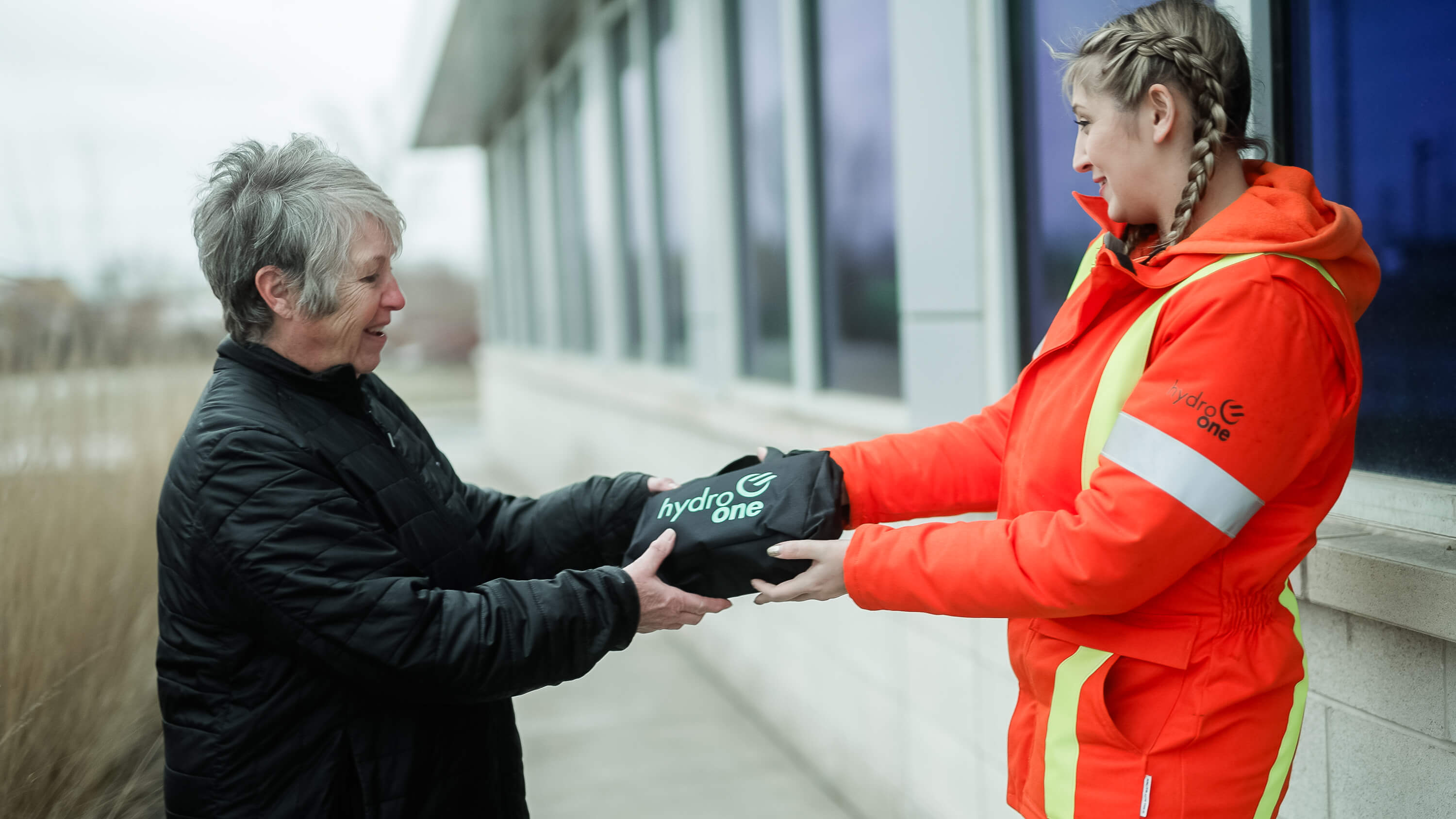 photo of a Hydro One worker handing an Emergency Preparedness kit to a customer