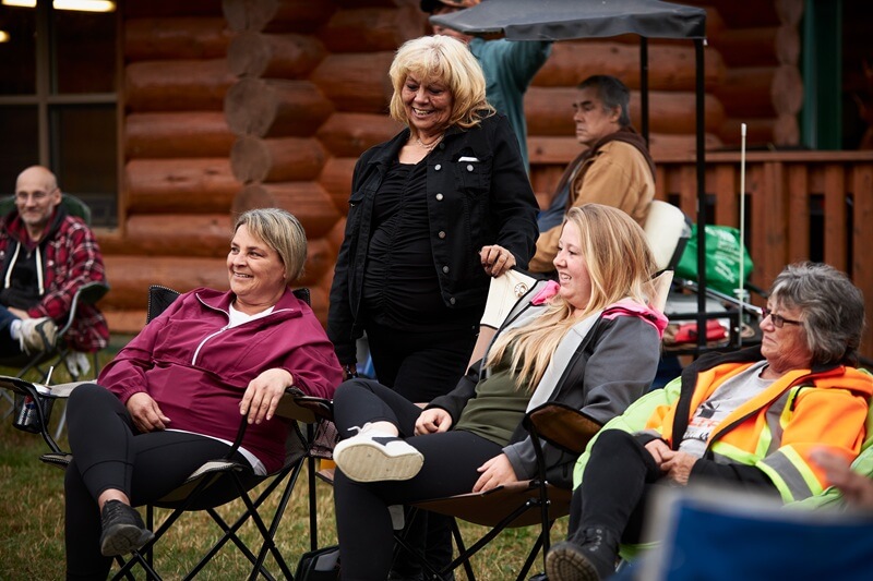 A group of people sitting outdoors at a community event in Matachewan.