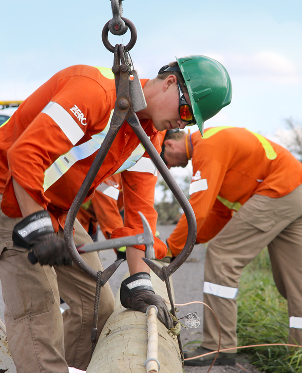 Hydro One employees working on a wood pole installation