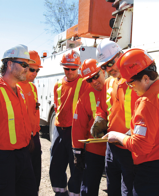 six Hydro One employees in a team huddled onsite