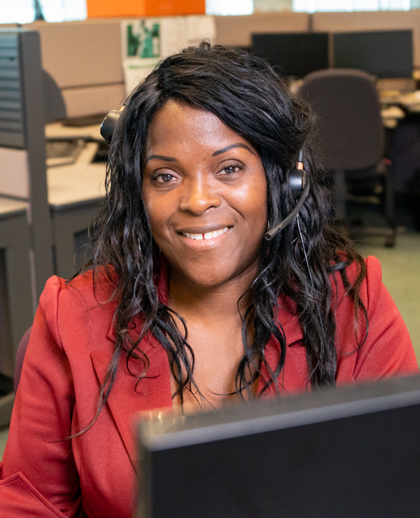 a womam in a red suit at a desk working at a call centre