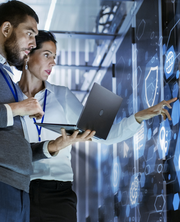 a man and a woman in an office looking at a white board up close