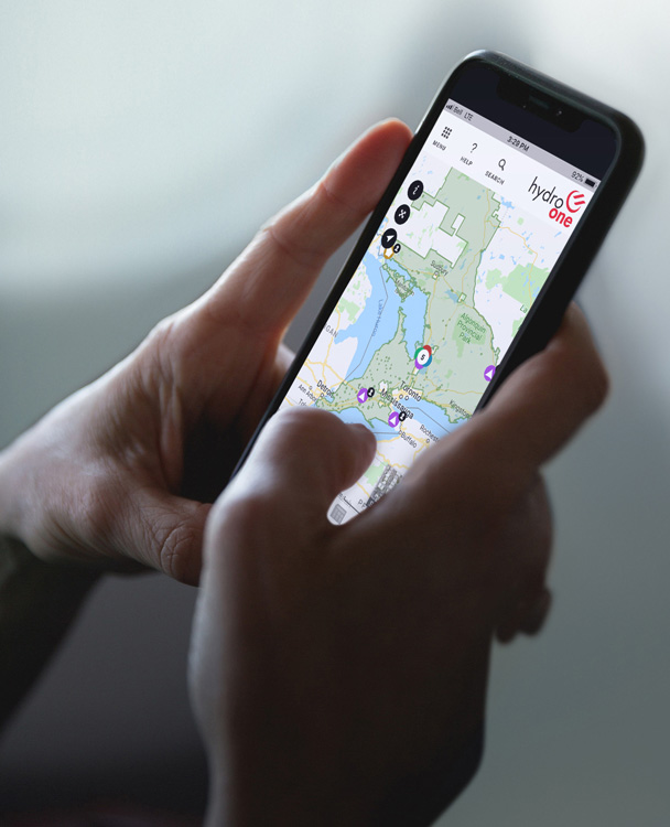 a user looking at the Hydro One storm app on a mobile phone