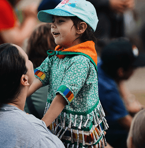 Indigenous mom holding up her child