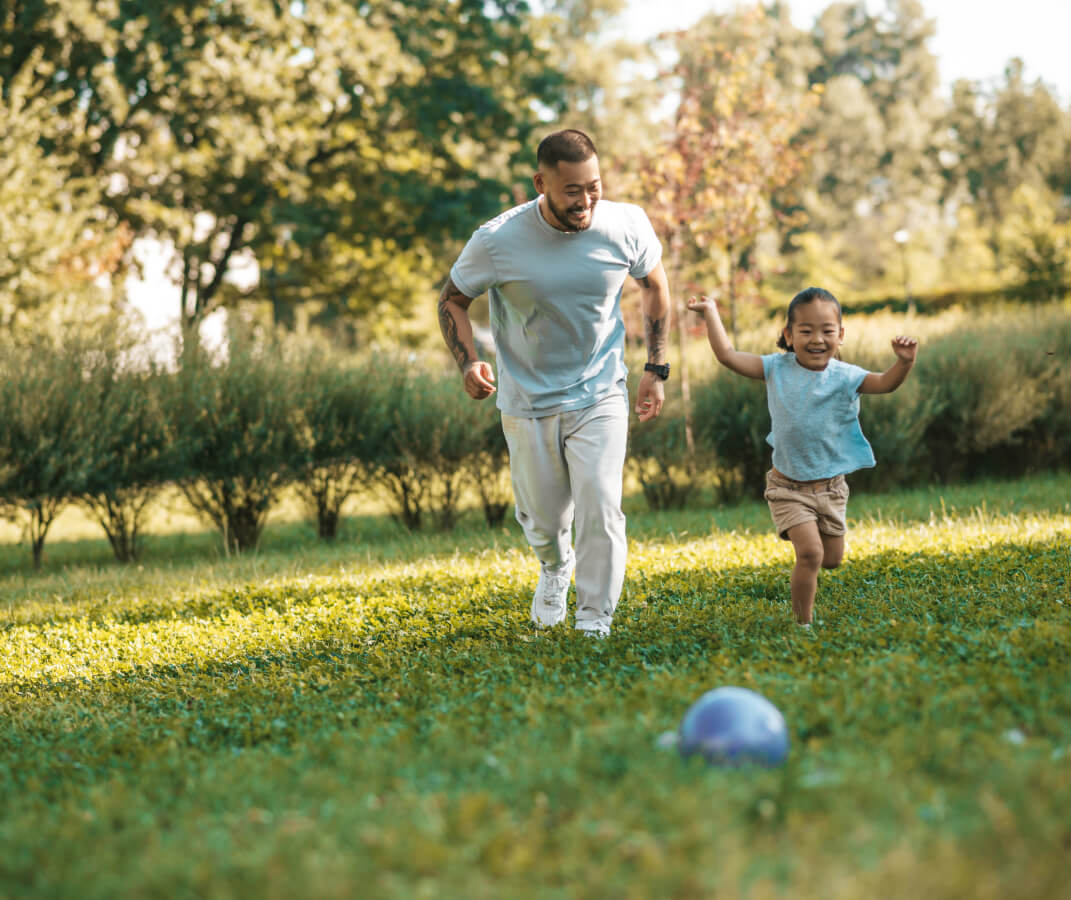 Father and daughter running in field together