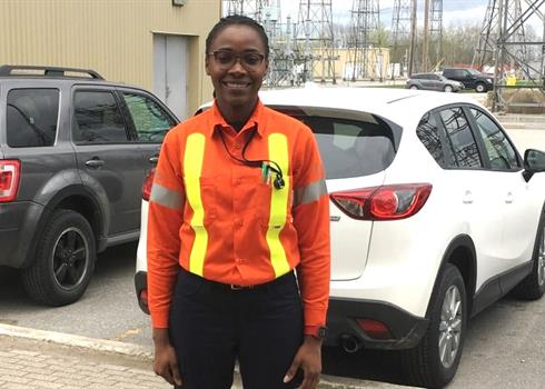 photo of Linda Chigbo standing in front of a Hydro One transformer station