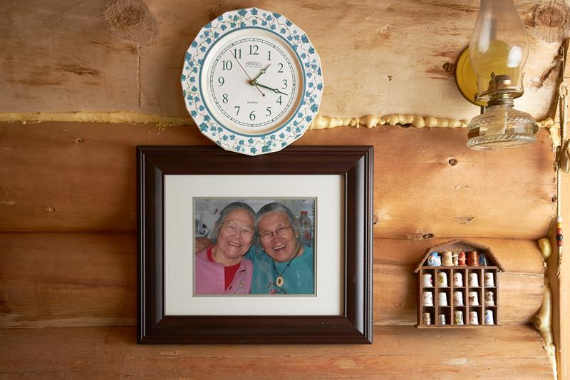 photo of an antique wall clock with a framed photo of two First Nations elders underneath it