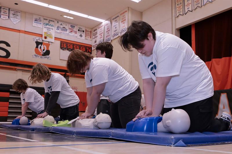 photo of teens learning how to perform CPR