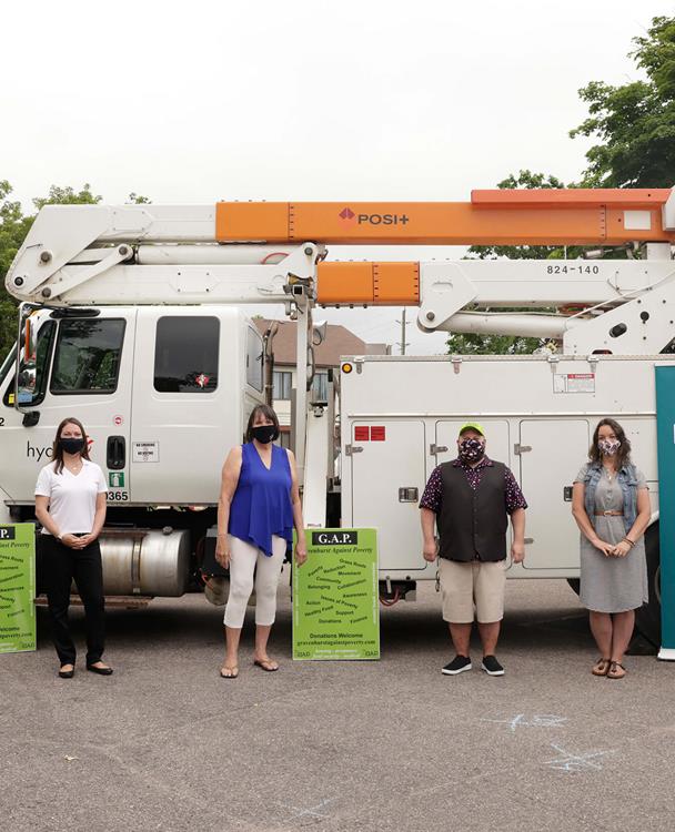 photo of Hydro One and Gravenhurst Against Poverty (GAP) representatives standing in front of a bucket truck in the summer of 2021