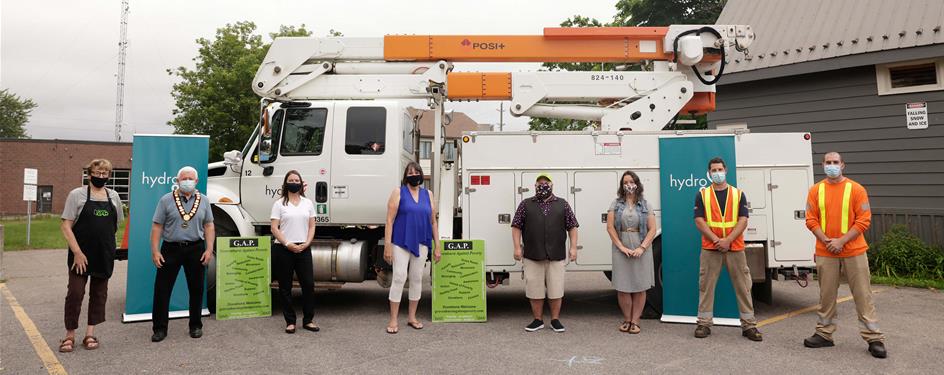 photo of representatives from Hydro One, the Town of Gravenhurst and Gravenhurst Against Poverty standing in front of a Hydro One bucket truck