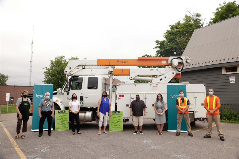 Photo of representatives from Hydro One, the Town of Gravenhurst and Gravenhurst Against Poverty standing in front of a Hydro One bucket truck