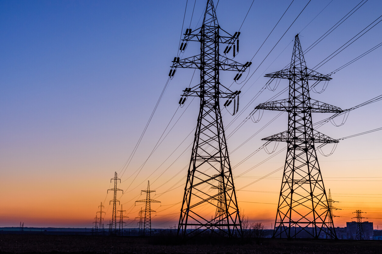 High voltage power line in a field at sunset