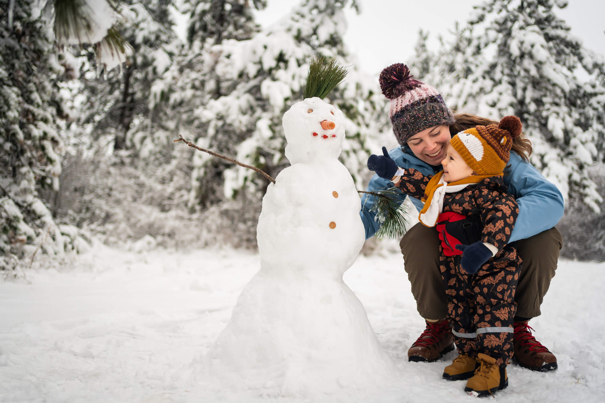 Mother and child building a snowman