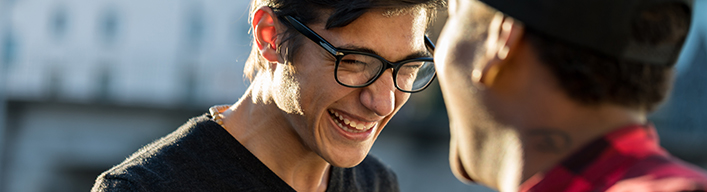 a close up shot of a man with glasses smiling