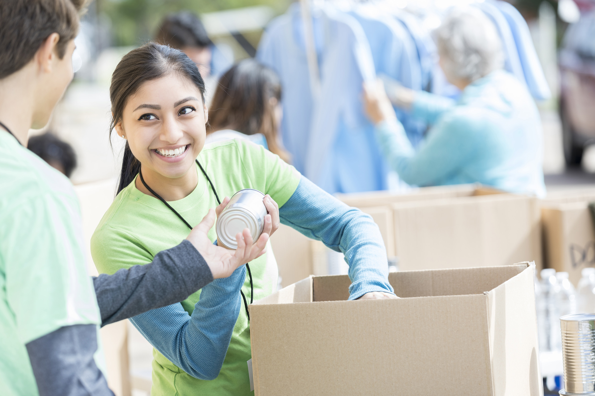 Woman distributing a can of non-perishables.