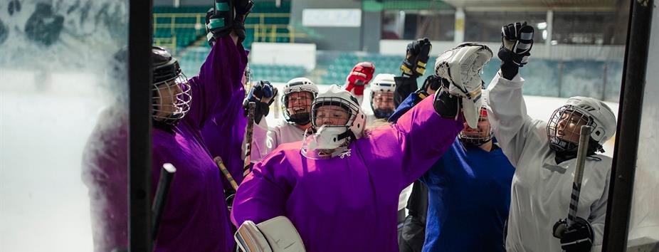 photo of kids playing hockey with helmets on