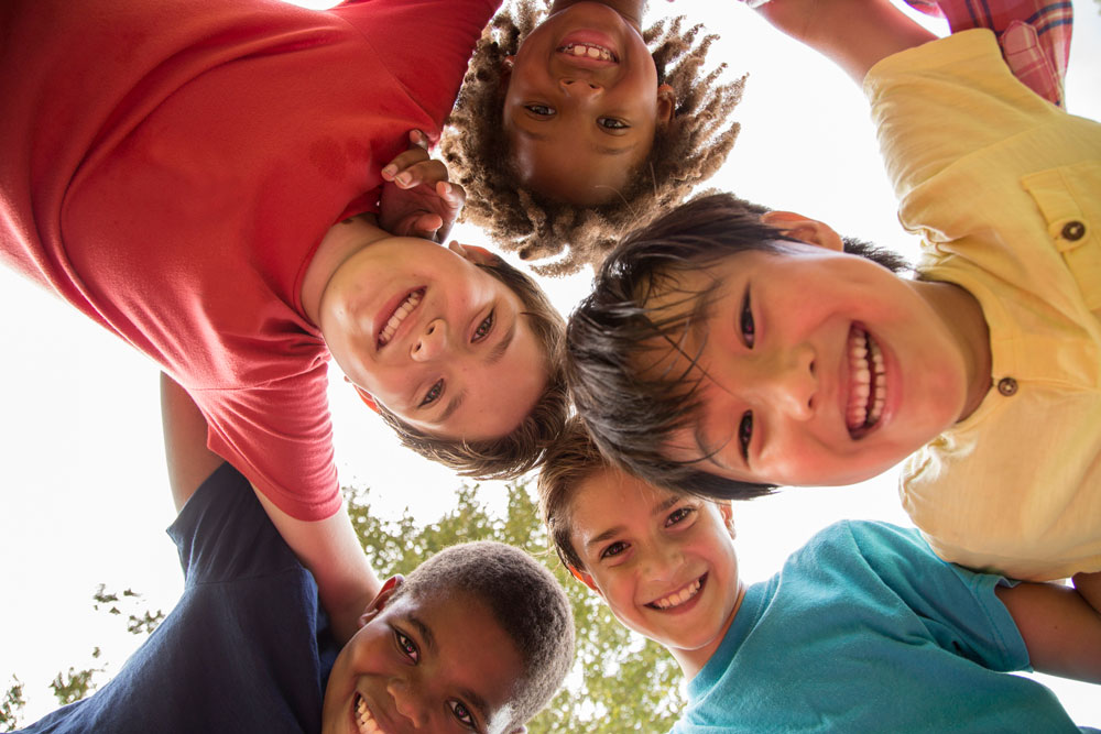 photo of a bunch of smiling kids looking down at the camera