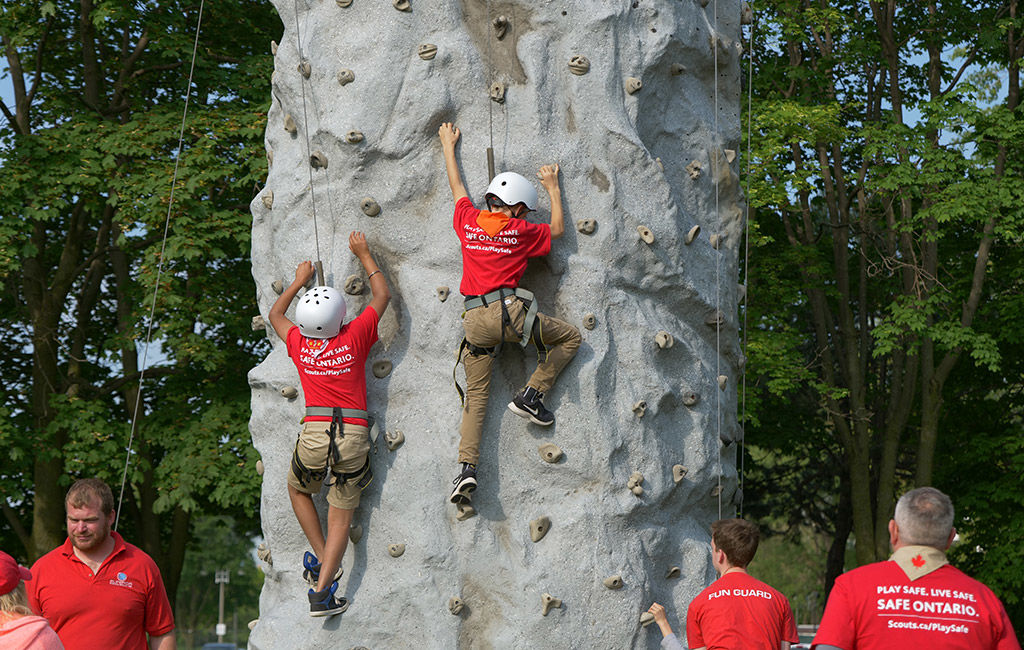 Children rock climbing a wall.