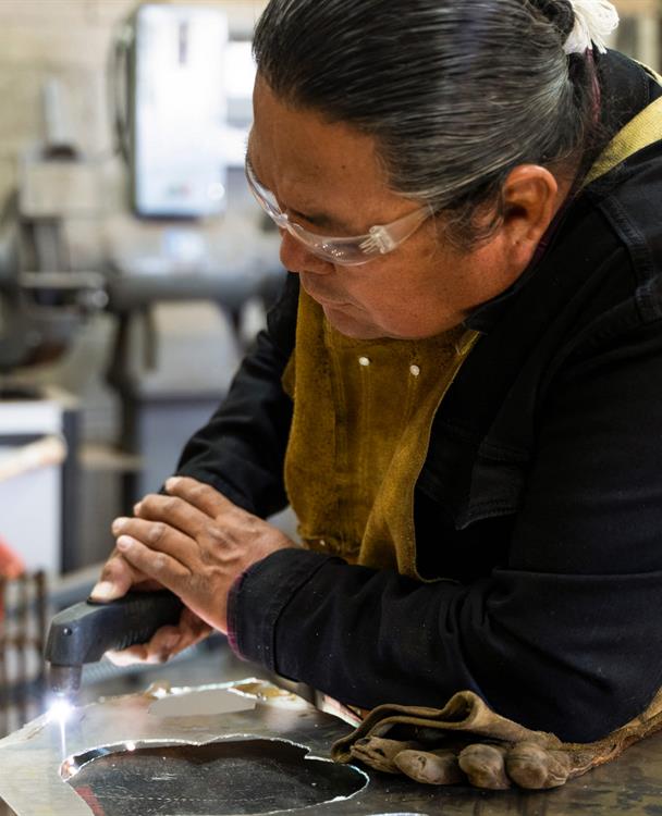 Image of indigenous woman welding