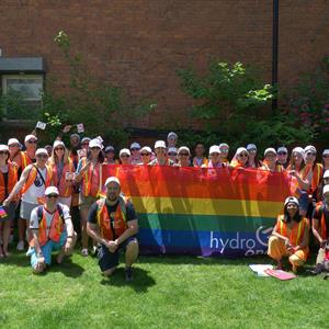 photo of a group of Hydro One employees holding a Pride flag