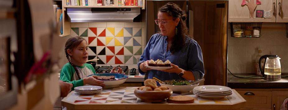 photo of an indigenous woman and child baking cupcakes