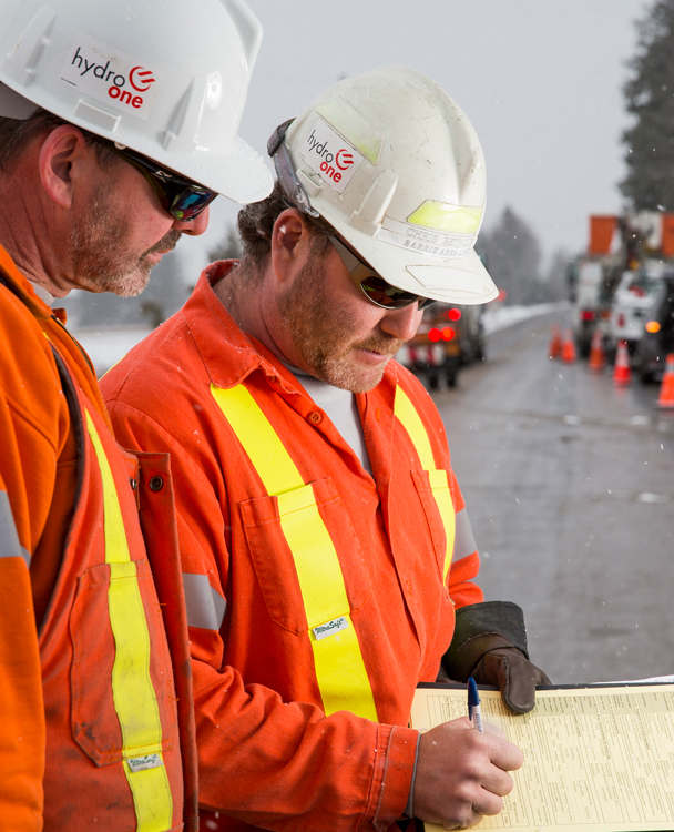 Two Hydro One workers conducting a tailgate safety meeting