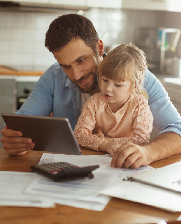 Father showing his daughter how to use a tablet computer