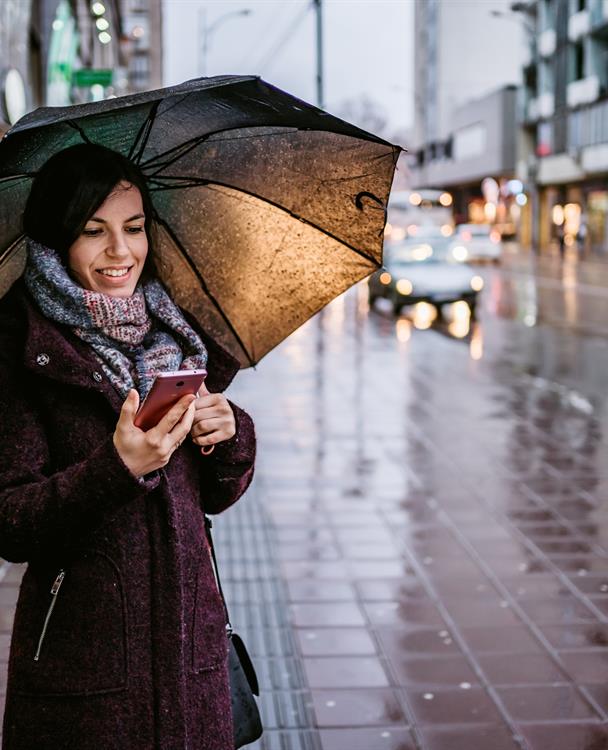 Photo of a woman using a mobile phone outside in winter