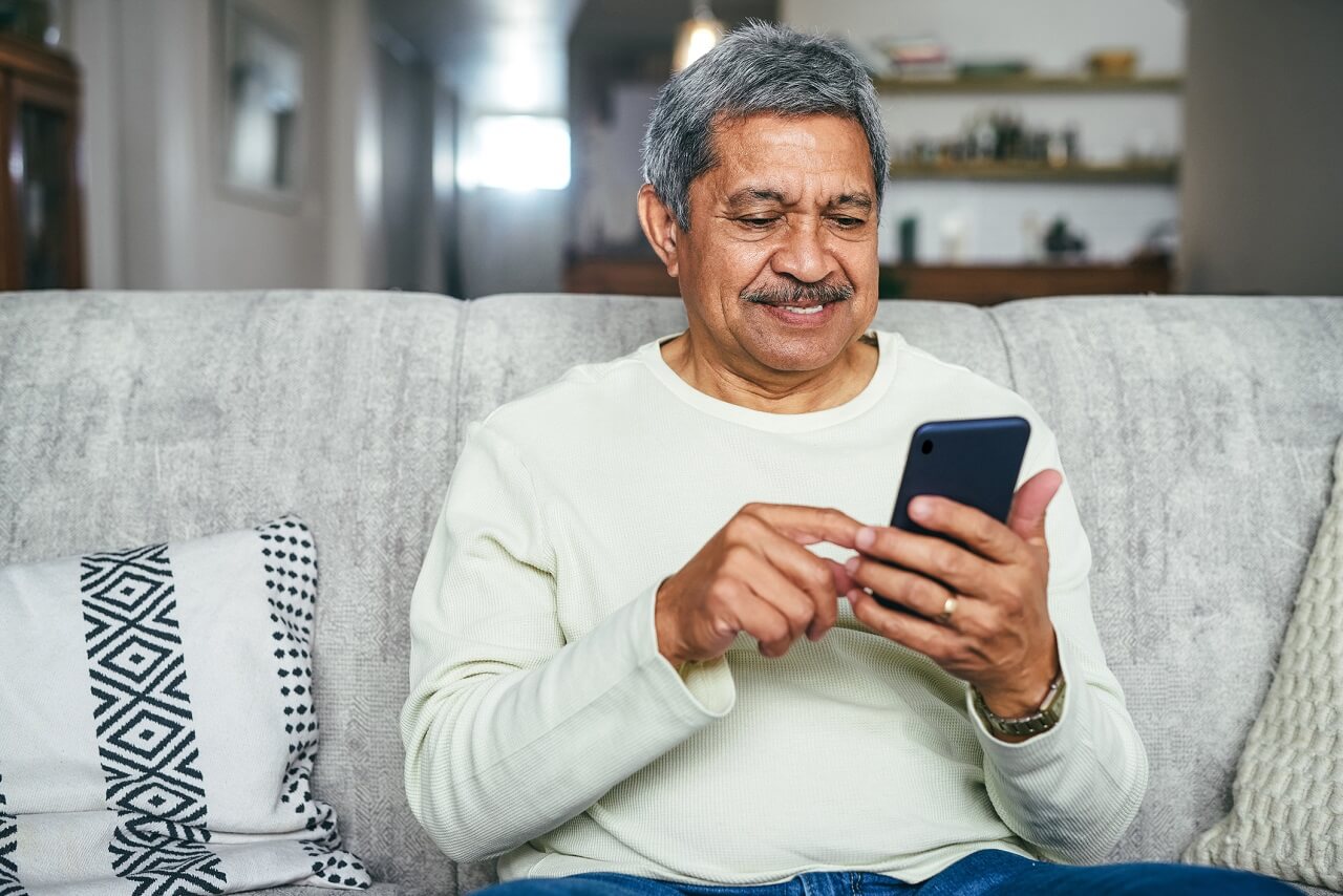 Man using phone sitting on a couch