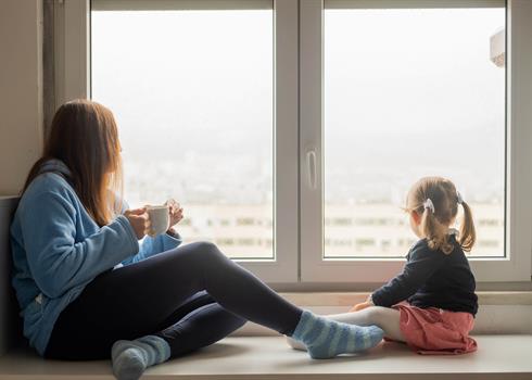 Mother and daughter looking out the window